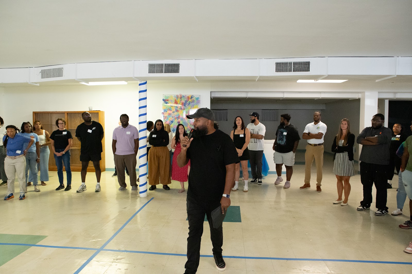 Neil Ray leading a standing circle of staff members