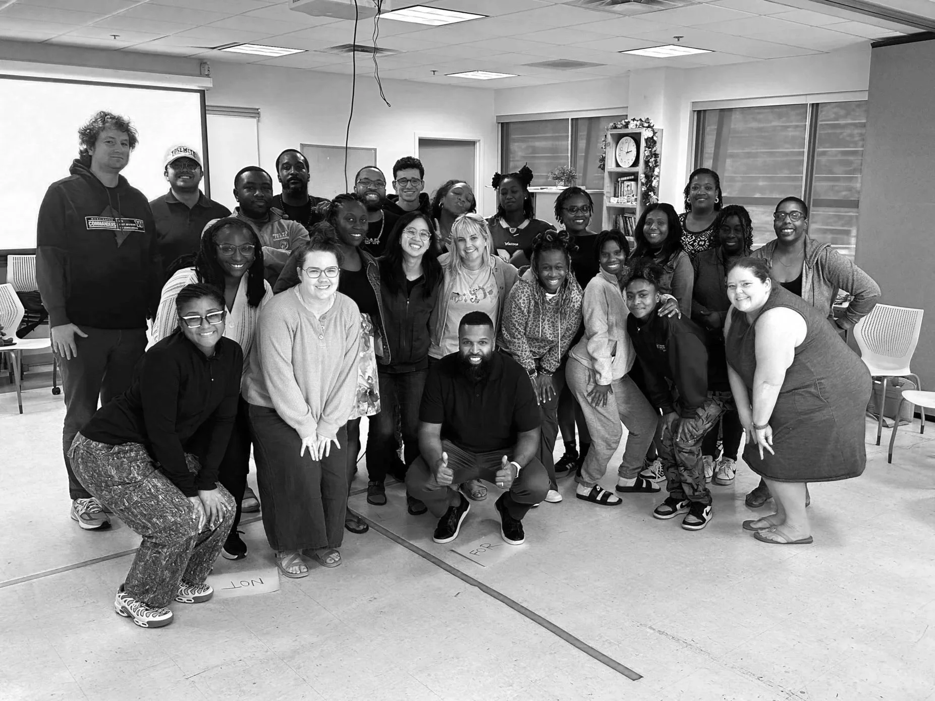 Neil Ray crouching in front of a smiling school staff group