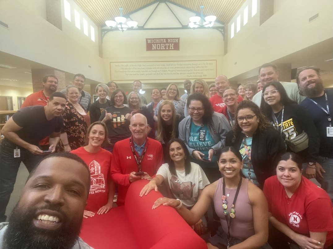 Neil Ray taking a group selfie with a smiling school staff